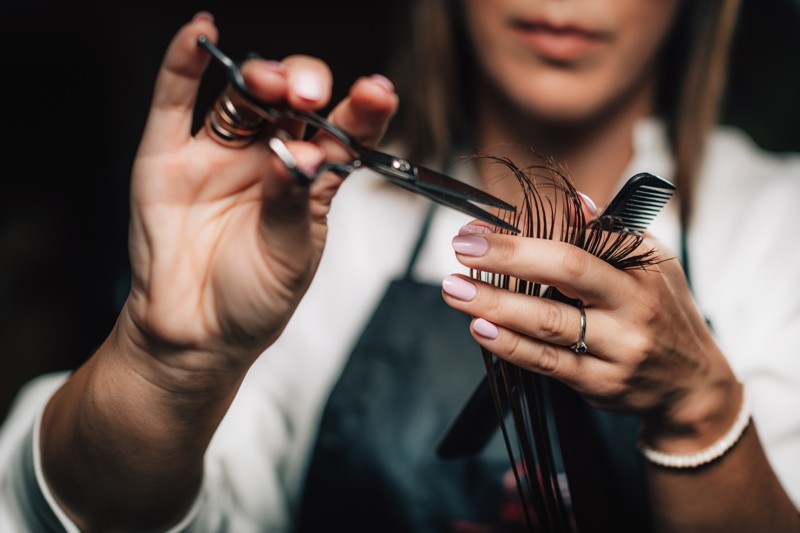 close up of a hairdresser cutting woman’s hair.